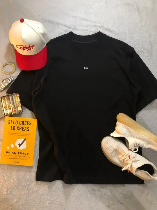 Camiseta Oversize Eros negra con gorra crema y roja, tenis y un libro