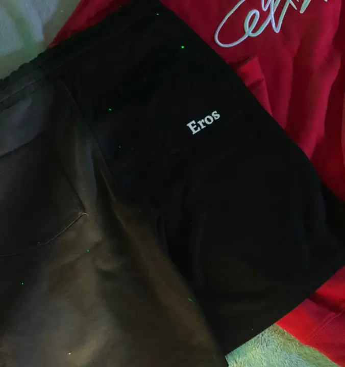 Bolsillo trasero de la pantaloneta negra con la palabra Eros